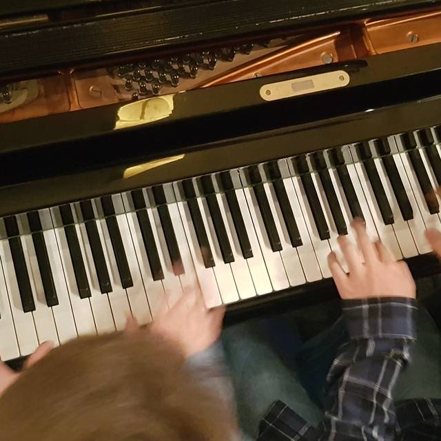 Kinder spielen Klavier beim Klavierkonzert.