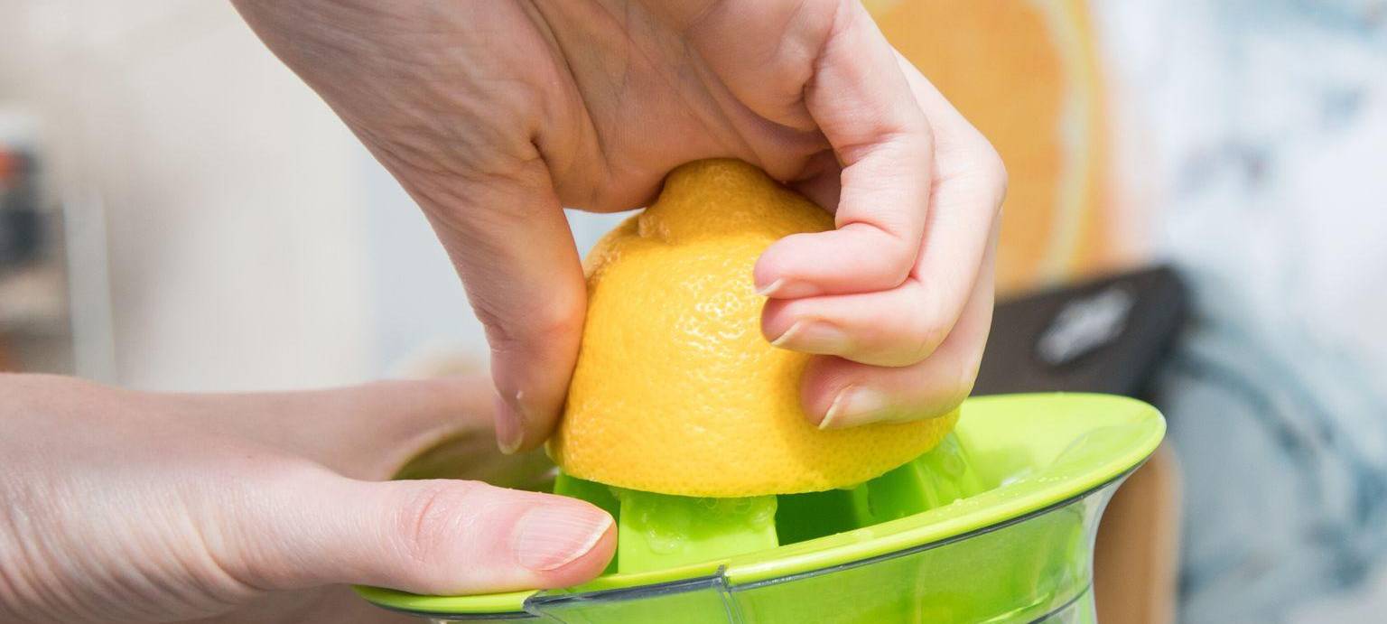 Eine Frau presst eine Zitrone aus