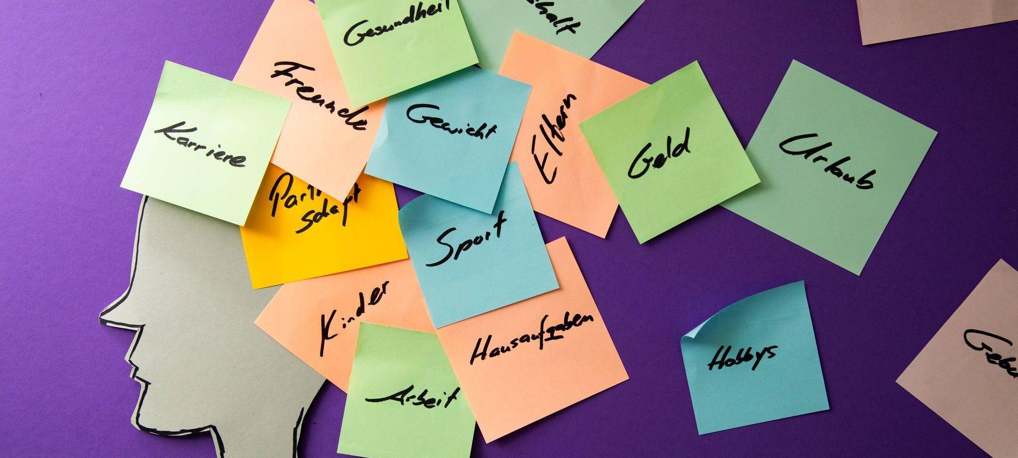 Eine Silhouette mit bunten Post-Its über dem Kopf