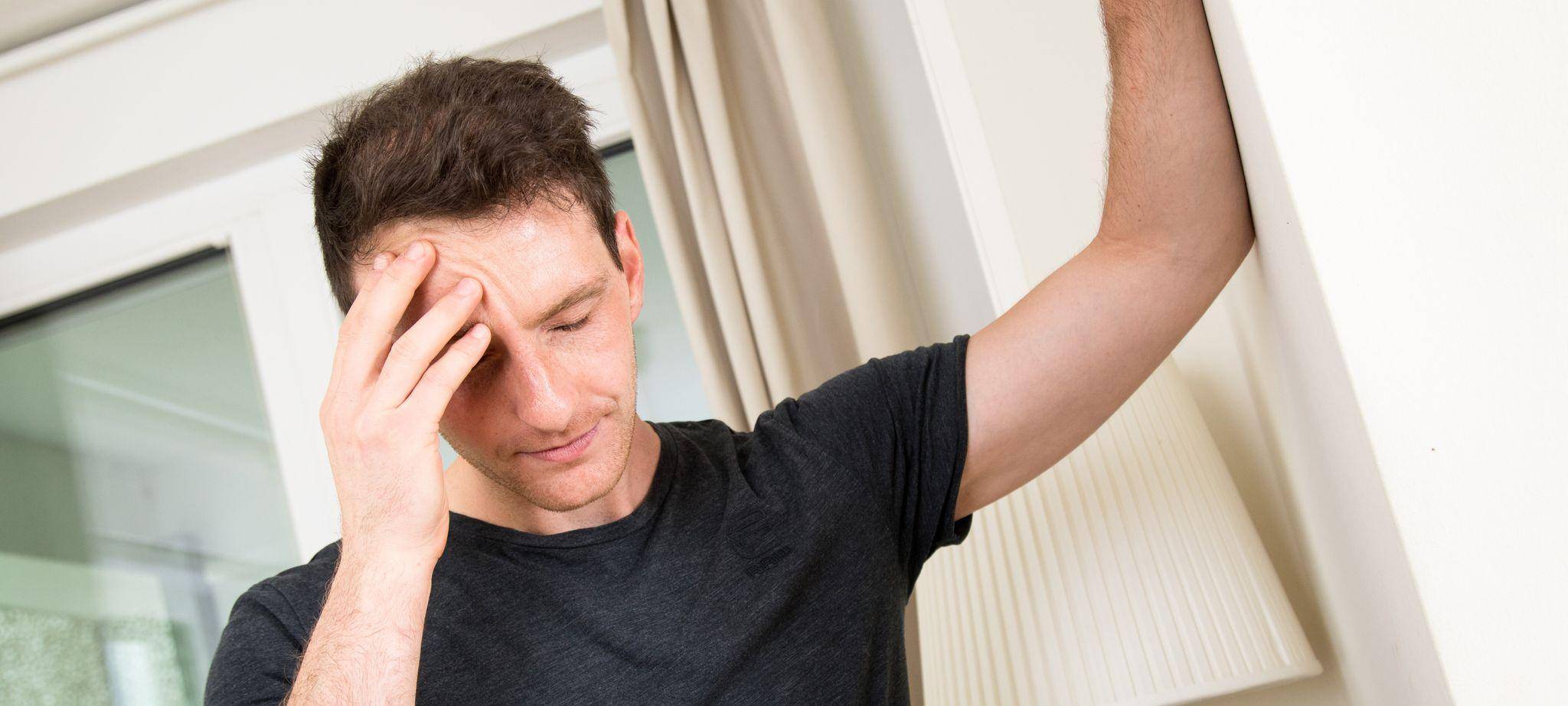 Mann hält sich den schmerzenden Kopf