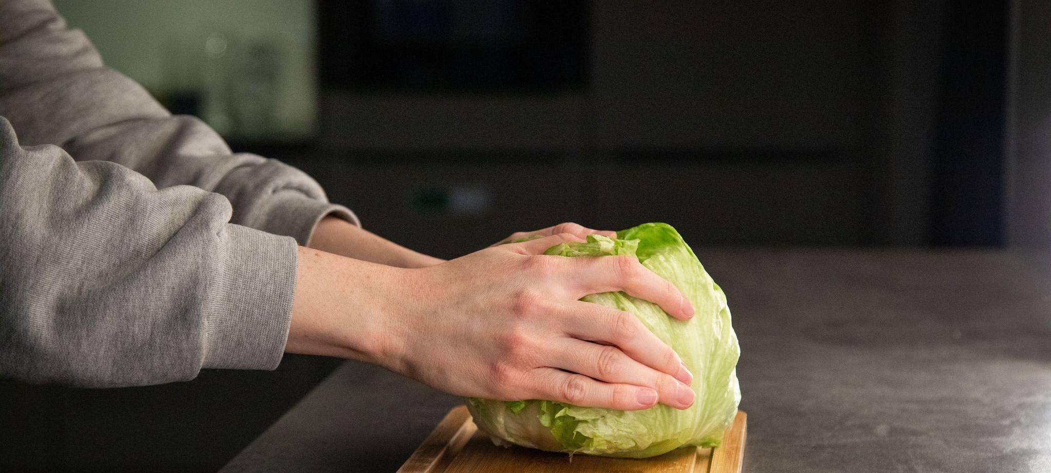 Salat liegt mit dem Strunk nach unten auf einer Arbeitsfläche