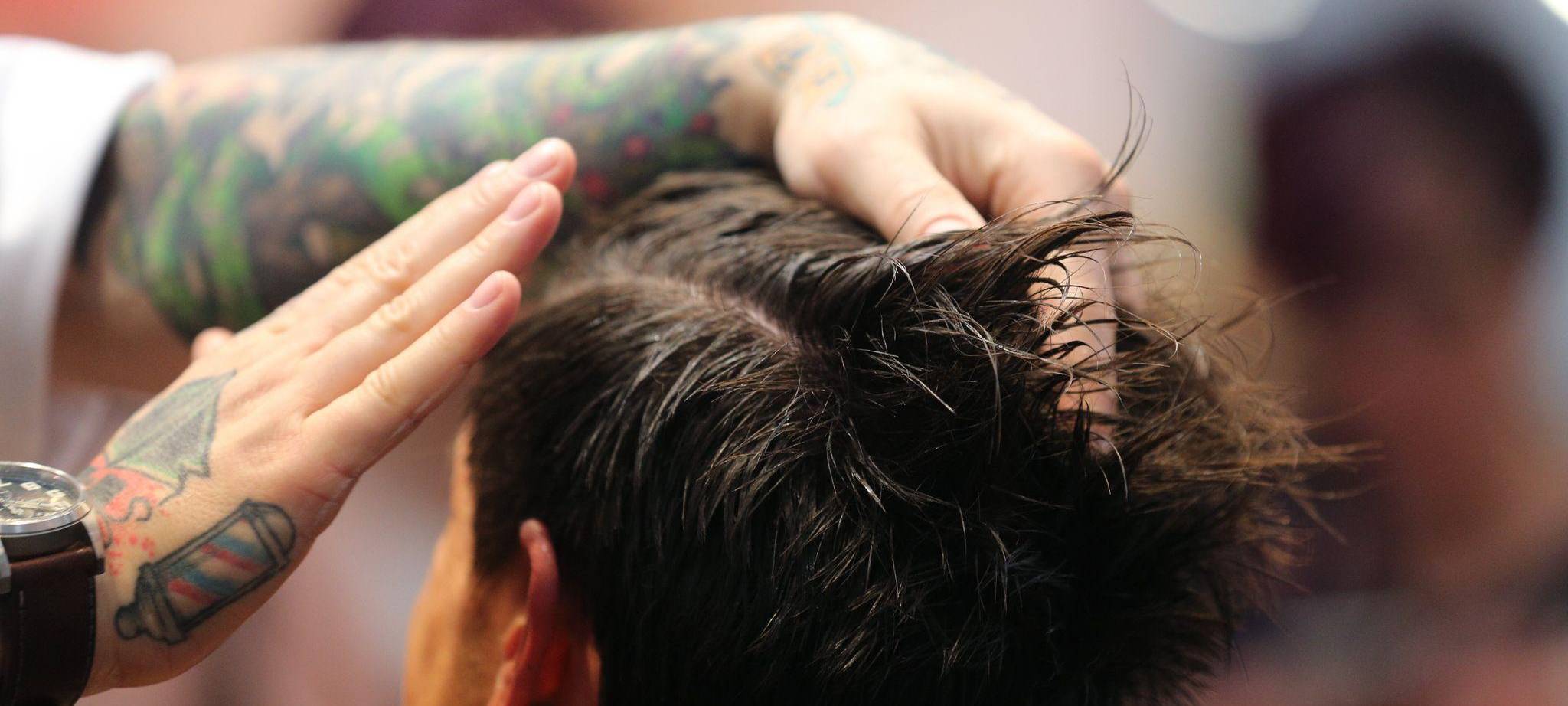 Friseur stylt die Haare eines Mannes mit Haargel