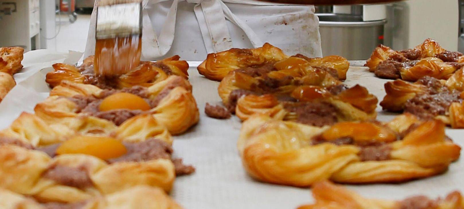 Bäcker glänzt Plundergebäck ab