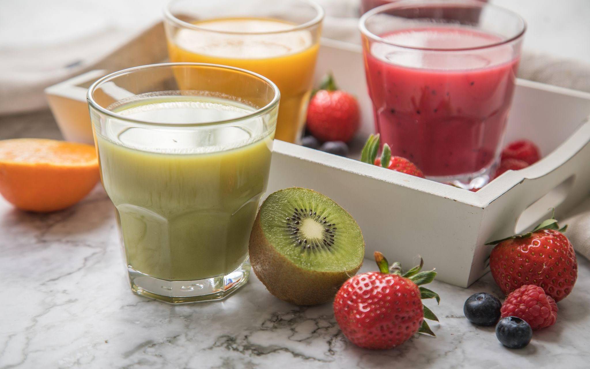 Mehrere Gläser mit frisch gepresstem Fruchtsaft